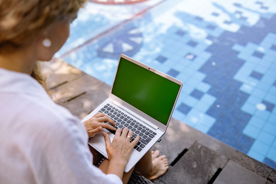 Bărbat la birou, cu laptopul deschis și un câine odihnit lângă scaun