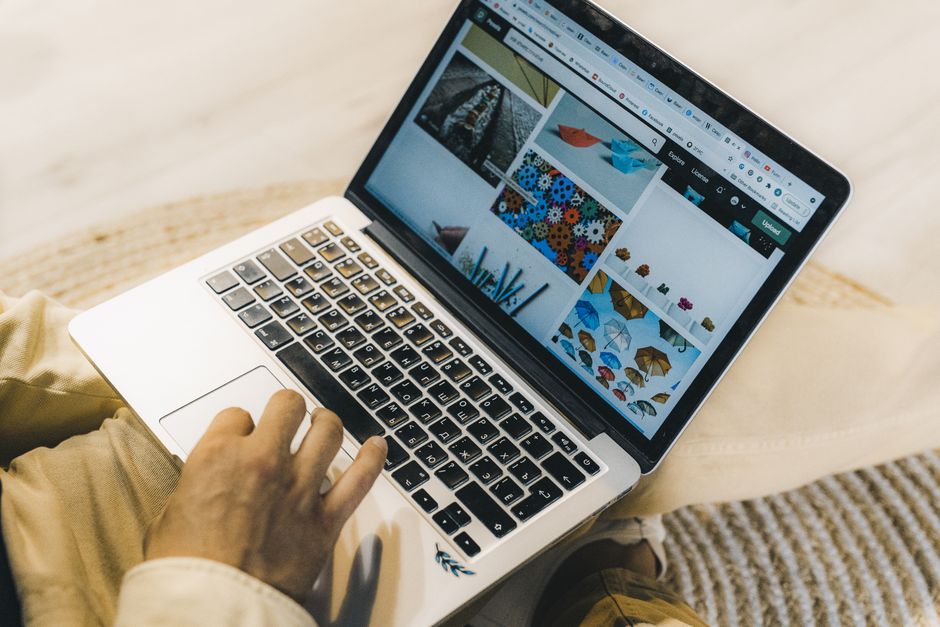 Un bărbat lucrează la laptop într-un birou, cu o agendă deschisă lângă tastatură