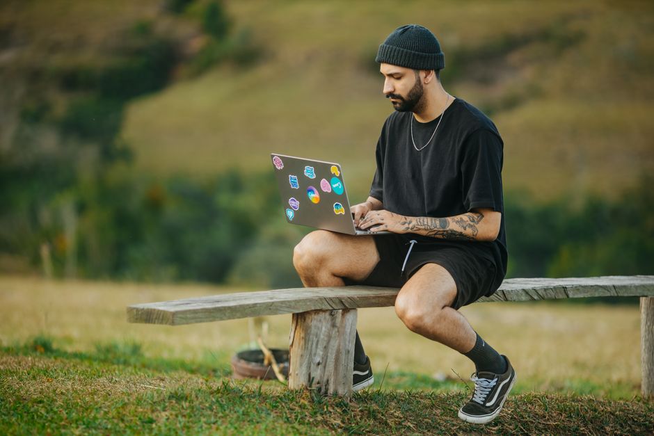 Om la birou, cu laptopul deschis și o ceașcă de cafea, privind calm ecranul