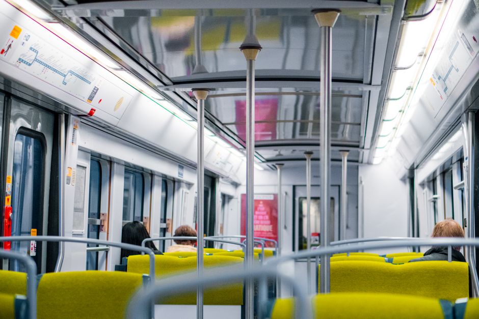 Navetist care citește într-un tren, lângă geam, într-o dimineață liniștită