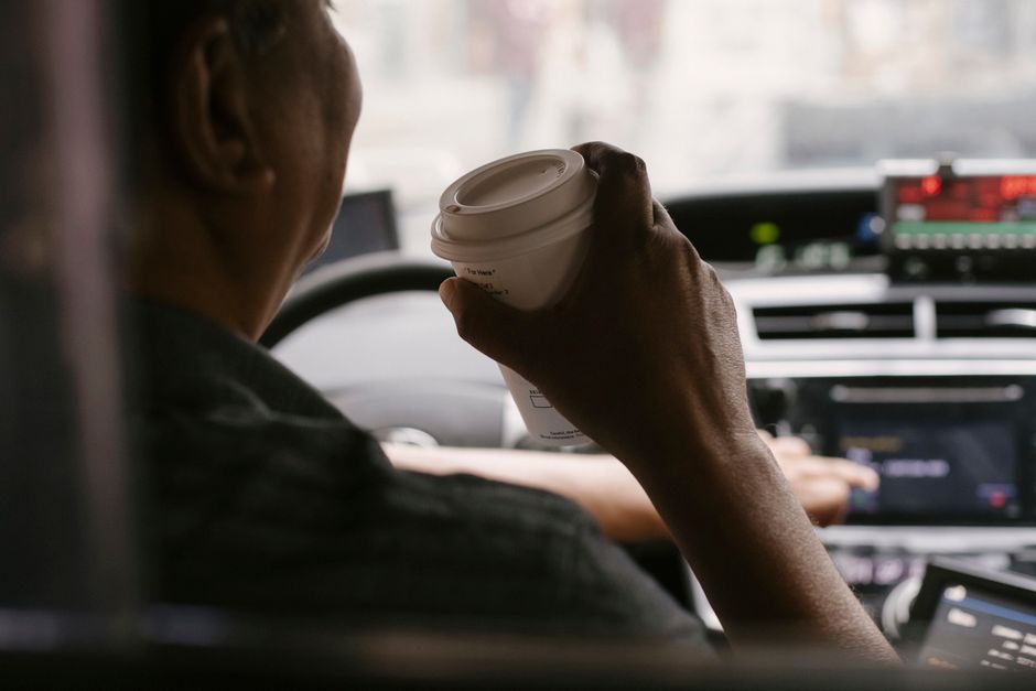 Doi colegi beau cafea pe o bancă, într-o pauză de la birou