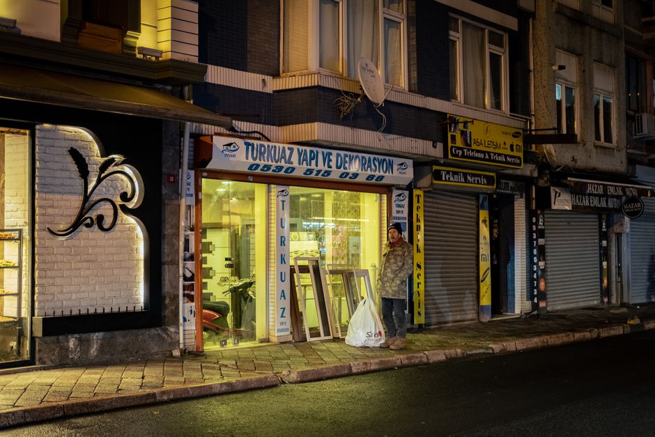O tânără împachetează un colet la o masă, într-un colț de apartament transformat în depozit