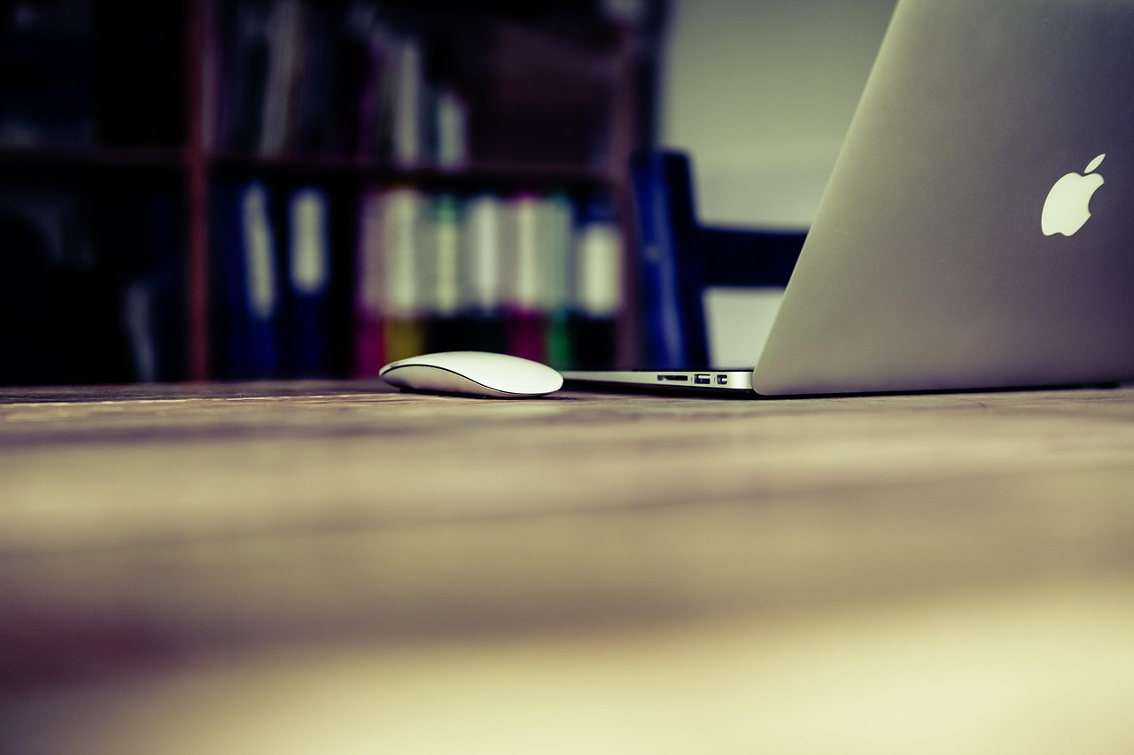 Bol cu iaurt și fructe lângă un laptop, pe masa din sufragerie
