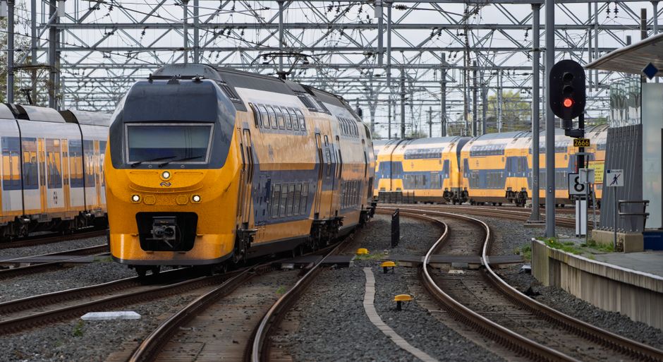 Navetistă care privește pe geamul unui tren într-o dimineață cenușie
