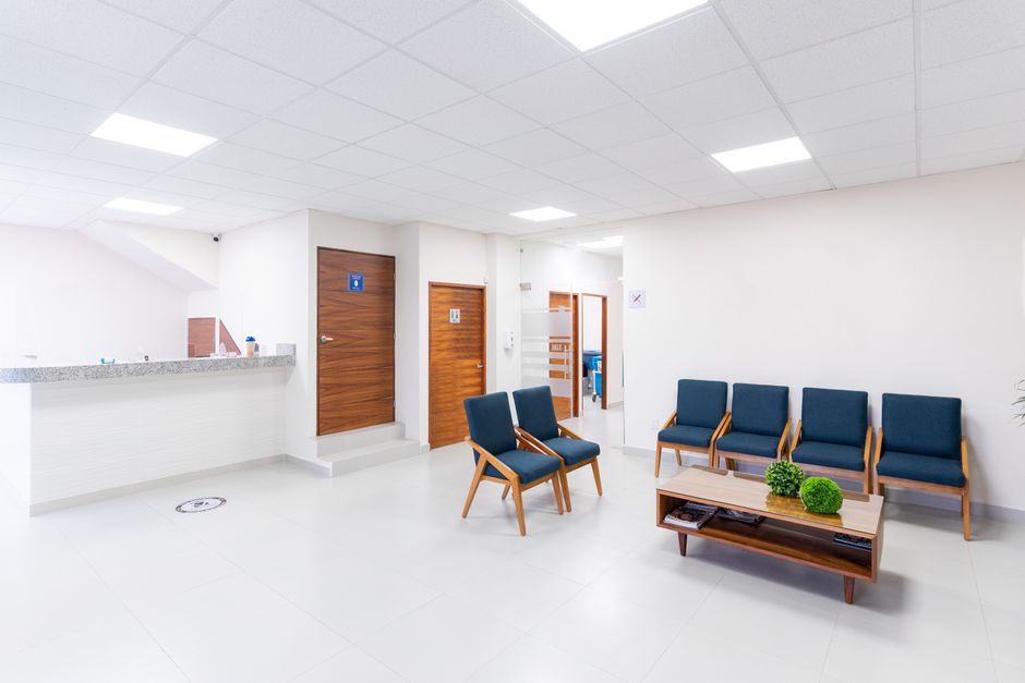 O persoană intră într-un apartament gol, cu lumină multă la ferestre