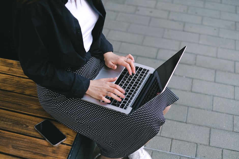 Bărbat cu documente și un laptop deschis la o masă de lucru, într-o cameră luminoasă