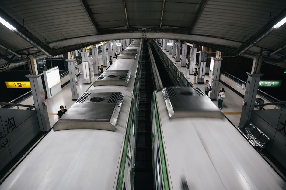 Pasager într-un tren de dimineață, cu laptopul deschis pe masa de lângă geam