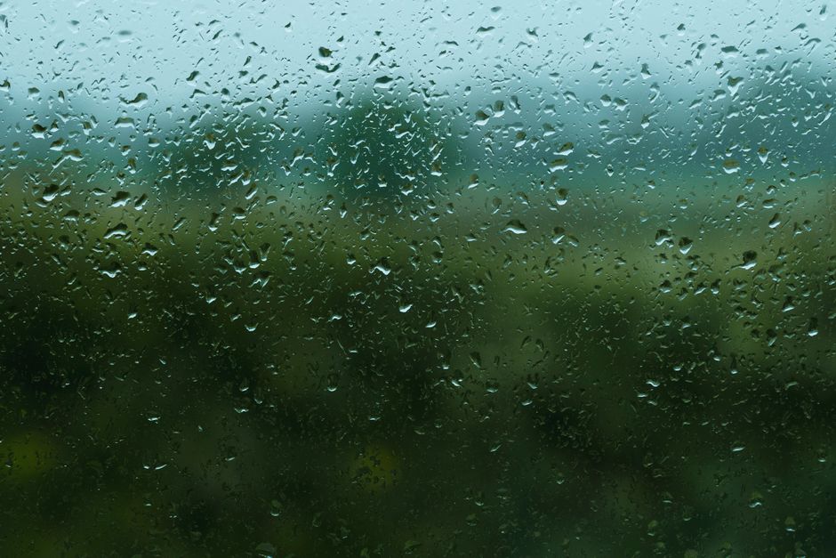 Picături de ploaie pe geamul unei ferestre, văzut dinăuntru