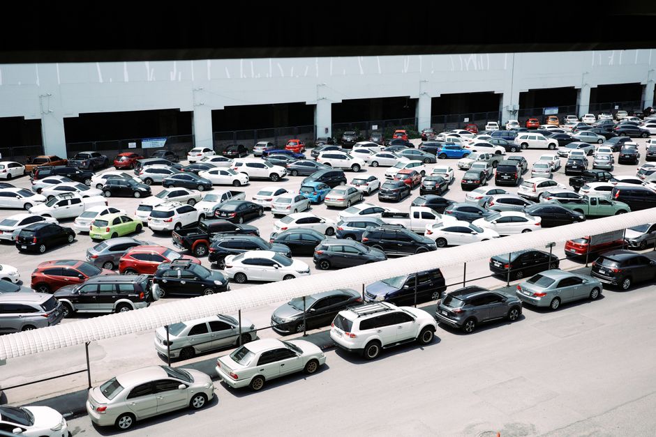 Tânăr care verifică împreună cu un om mai în vârstă o mașină second-hand, cu capota deschisă