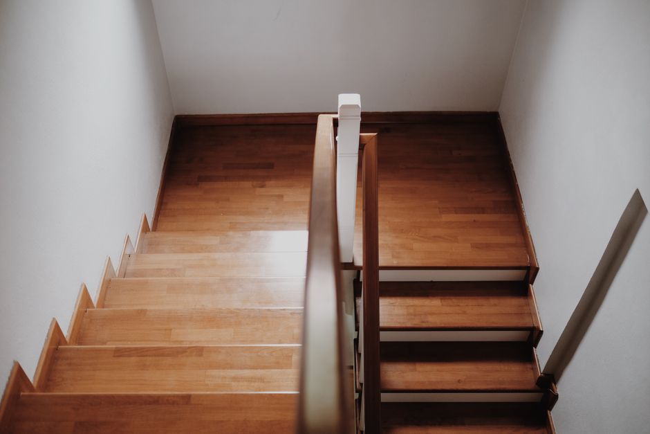 Poartă veche de lemn la intrarea într-un sat, cu dealuri verzi în fundal