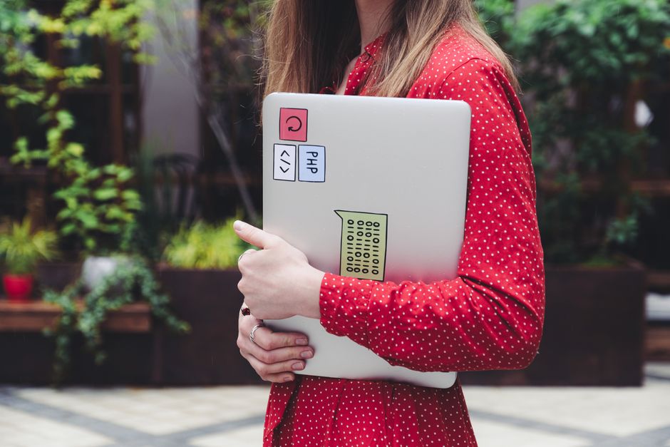 Birou cu laptop deschis pe un grafic și o cană de cafea alături de un carnet