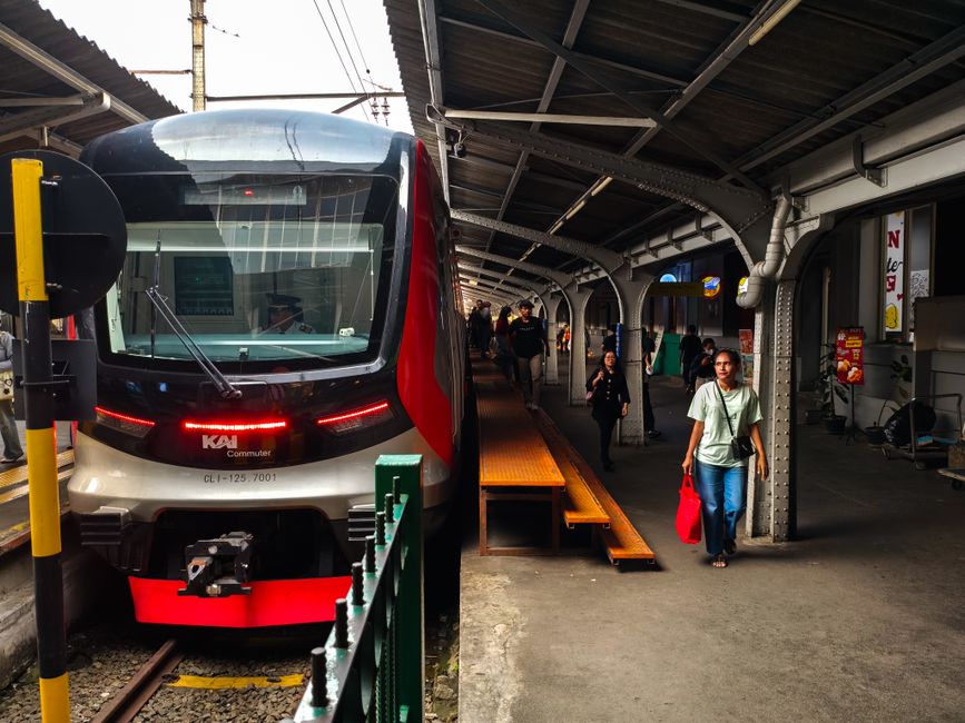 Pasager într-un tren, cu un caiet pe genunchi și un telefon în mână