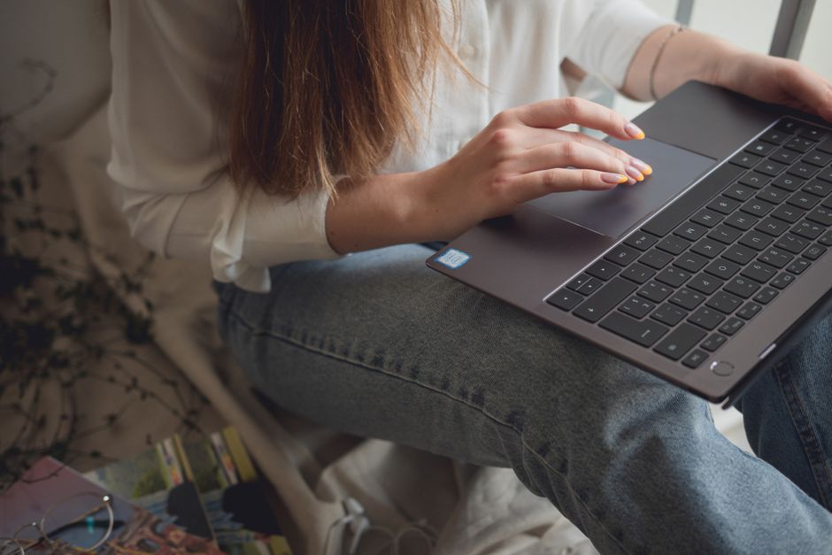 Fotograf care lucrează la laptop lângă un aparat foto pe birou