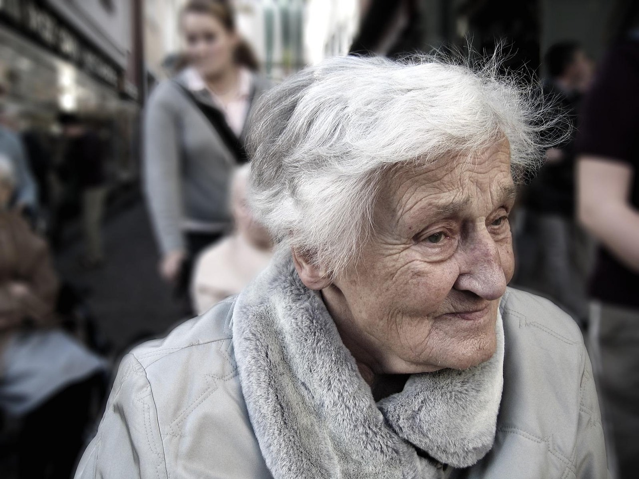 Bătrână care povestește la masă, cu un caiet deschis și un telefon așezat în față