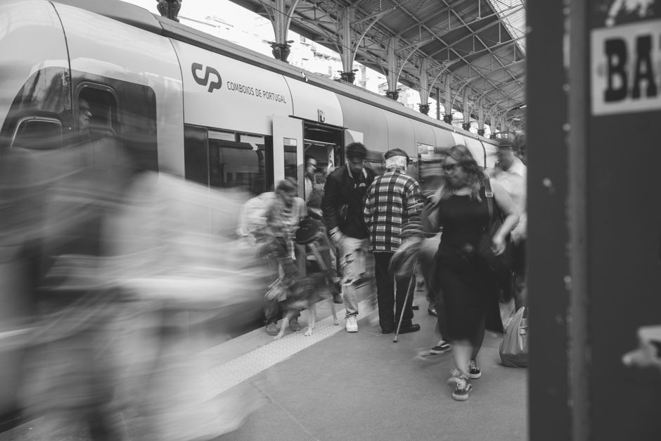 Un navetist lucrează pe laptop într-un compartiment de tren, seara